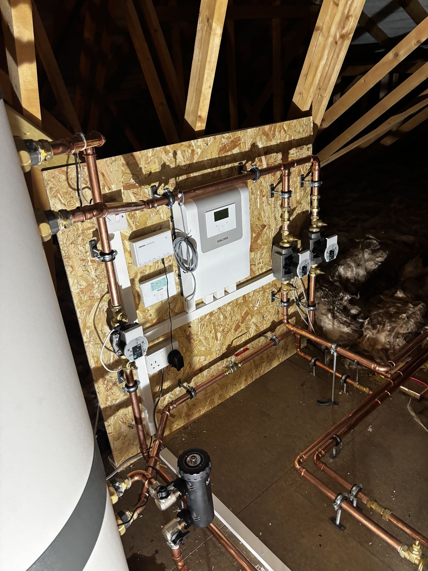Heat pump pipework, pumps and controls fitted in a loft plant space