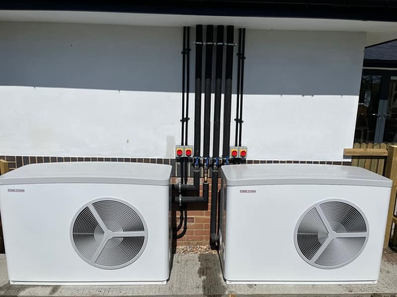 Two air source heat pumps installed by Solwat outside a home