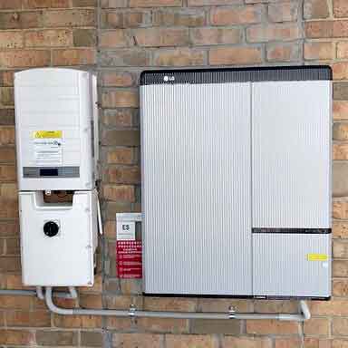 LG Chem home battery mounted on a brick wall beside an inverter